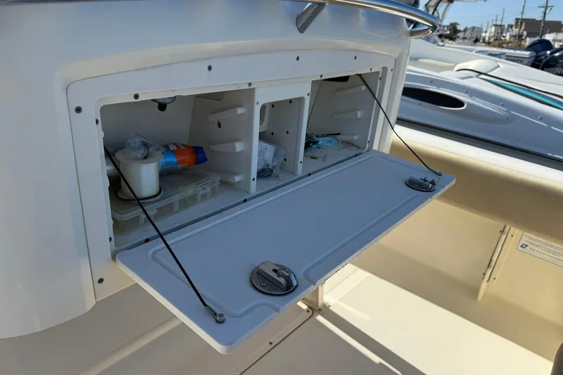 Slide: The Image of Storage compartment on a 2012 Scout 240 Bay Scout boat, open with various items inside. - 26