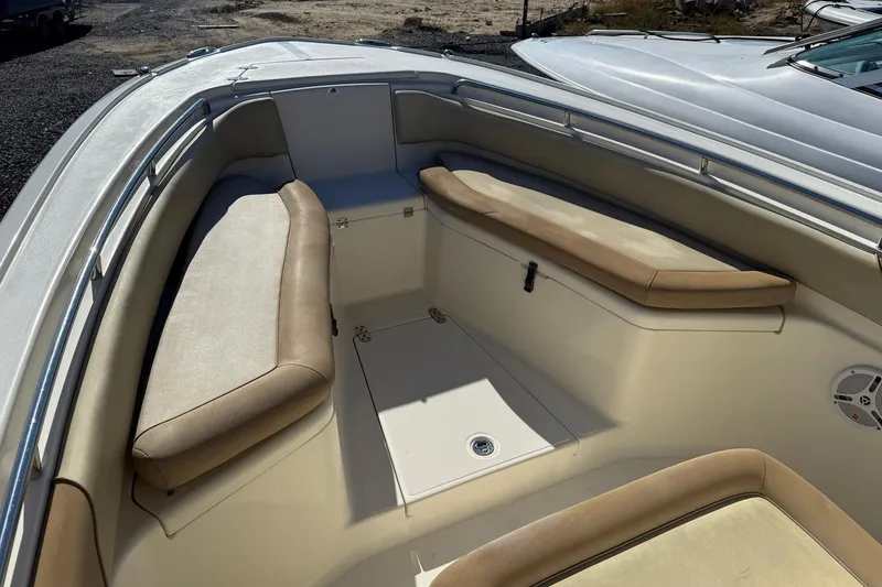 Slide: The Image of 2012 Scout 240 Bay Scout boat interior with cushioned seating and storage compartments. - 4