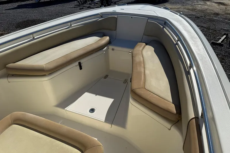 Slide: The Image of 2012 Scout 240 Bay Scout boat interior with cushioned seating and storage. - 5
