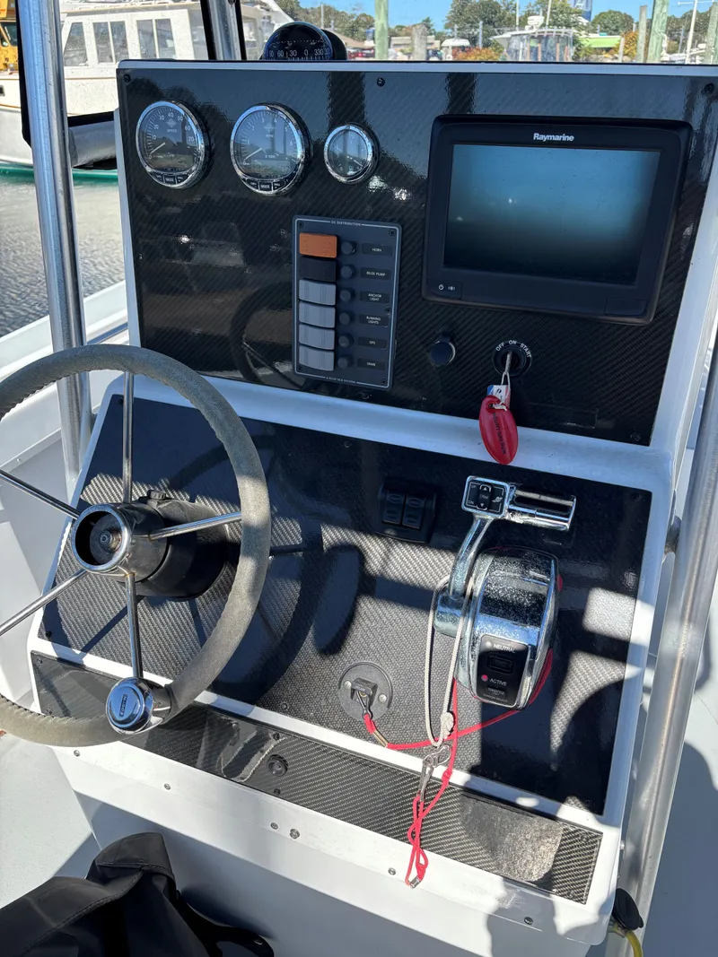 Slide: The Image of 1988 SeaCraft 23 Center Console dashboard with steering wheel and navigation controls. - 10