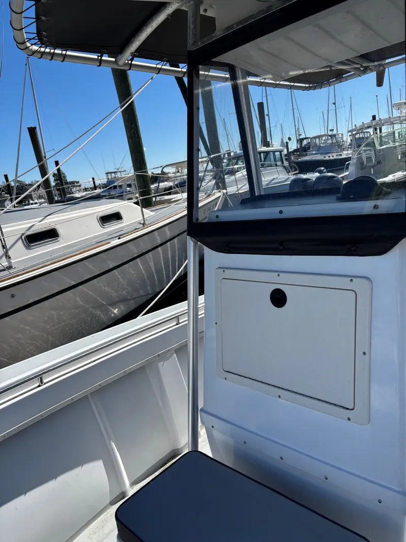 Slide: The Image of 1988 SeaCraft 23 Center Console boat interior at marina, surrounded by other boats. - 13