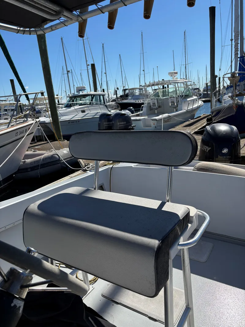 Slide: The Image of 1988 SeaCraft 23 Center Console boat at marina, featuring cushioned seating and Mercury outboard motor. - 14