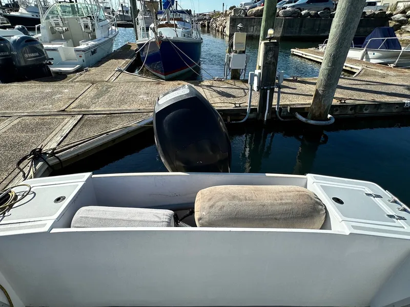 Slide: The Image of 1988 SeaCraft 23 Center Console boat docked at marina with outboard motor. - 15