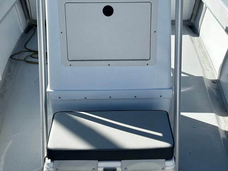 Slide: The Image of 1988 SeaCraft 23 Center Console boat interior with cushioned seat and storage compartment. - 17