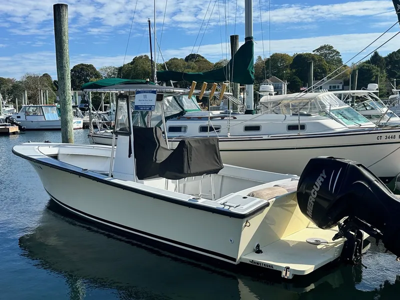 Slide: The Image of 1988 SeaCraft 23 Center Console boat docked in a marina with Mercury outboard motor. - 2