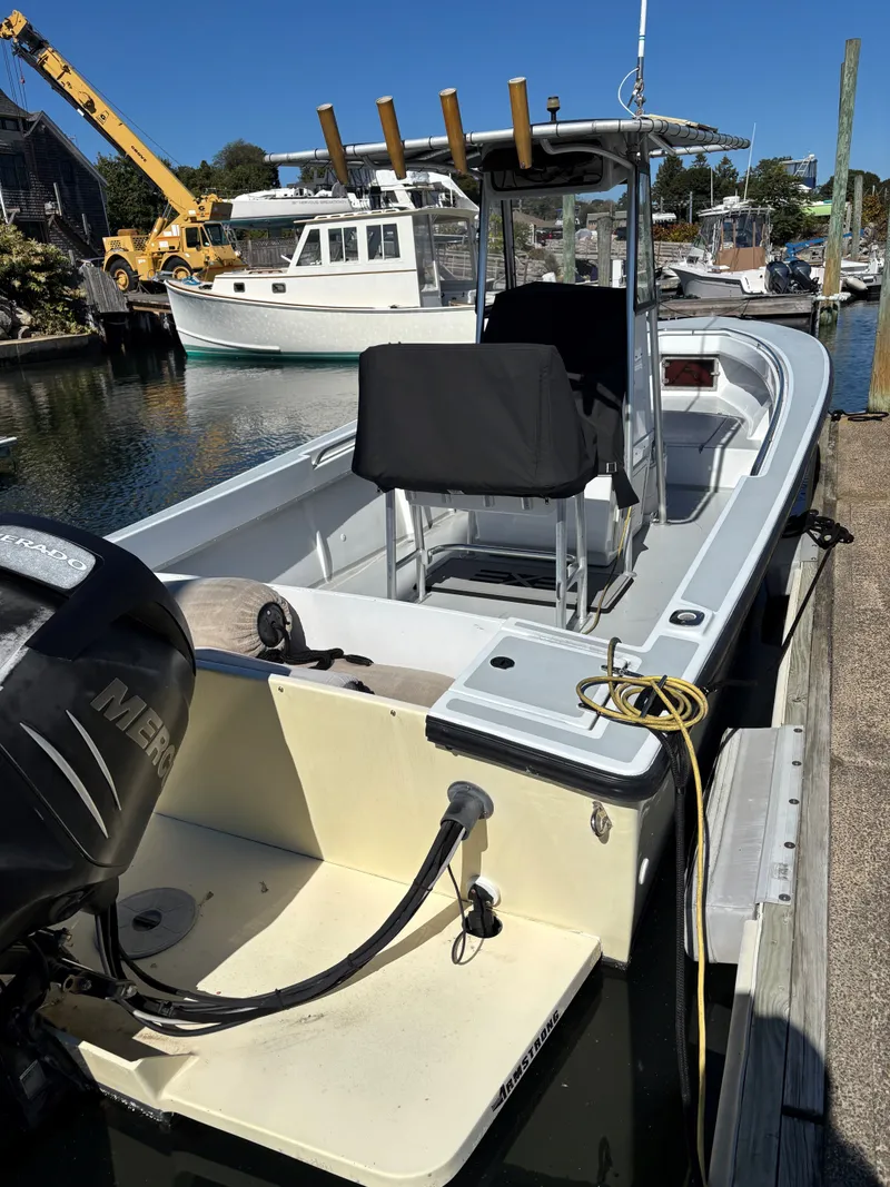 Slide: The Image of 1988 SeaCraft 23 Center Console boat docked, featuring a Mercury outboard motor. - 3