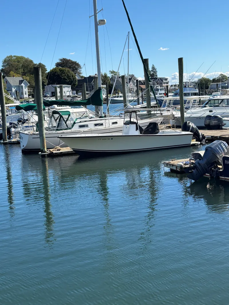 Slide: The Image of 1988 SeaCraft 23 Center Console boat docked in a marina on a sunny day. - 4