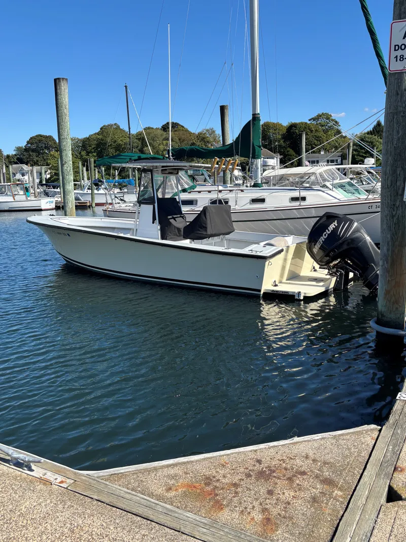 Slide: The Image of 1988 SeaCraft 23 Center Console boat docked in a marina with clear blue skies. - 5