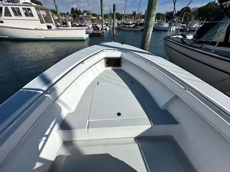 Slide: The Image of 1988 SeaCraft 23 Center Console boat docked in a marina, showcasing spacious deck. - 6
