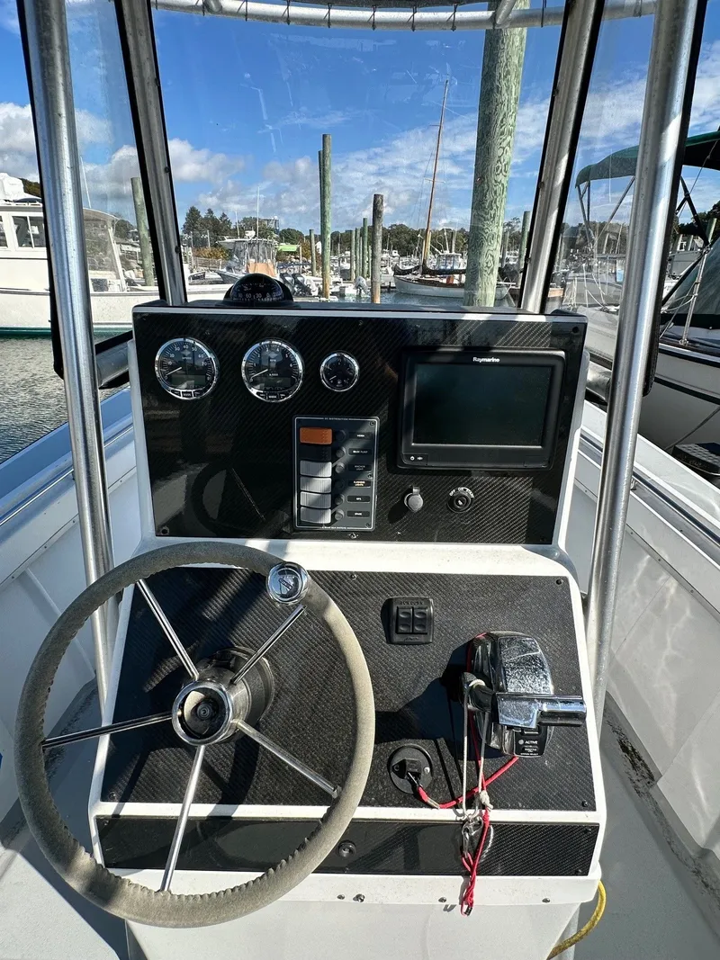 Slide: The Image of 1988 SeaCraft 23 Center Console helm with steering wheel, gauges, and navigation system. - 9