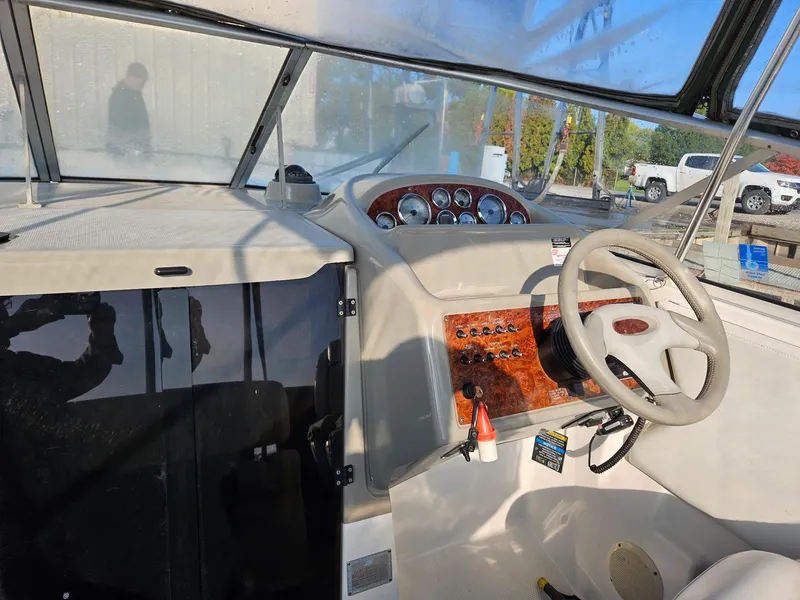 Slide: The Image of 1997 Bayliner 26 Cierra boat cockpit with steering wheel and control panel. - 2