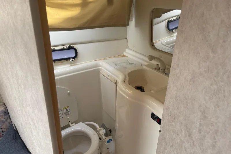 Slide: The Image of 1997 Bayliner 2655 Ciera boat bathroom with toilet, sink, and small window. - 23