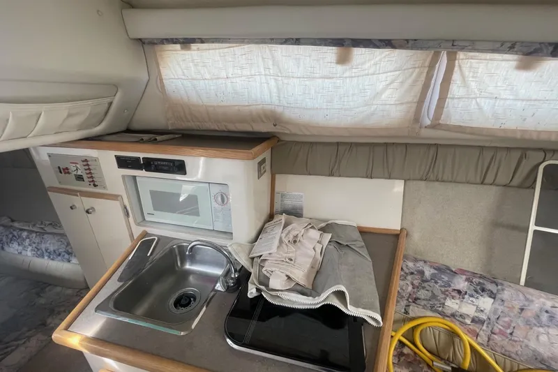 Slide: The Image of 1997 Bayliner 2655 Ciera boat on trailer, featuring a green canopy and sleek design. - 26