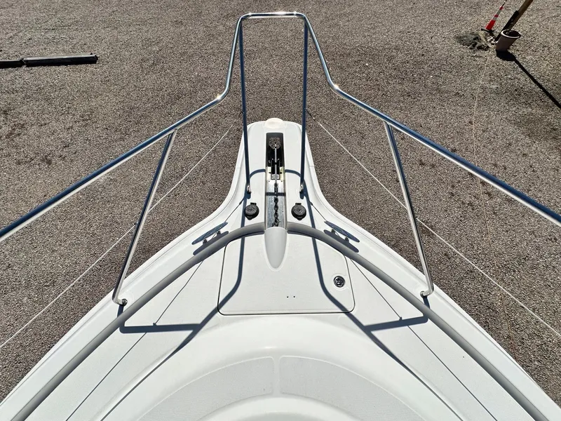 Slide: The Image of 2004 Silverton 38 Convertible boat bow with stainless steel railings on gravel surface. - 14