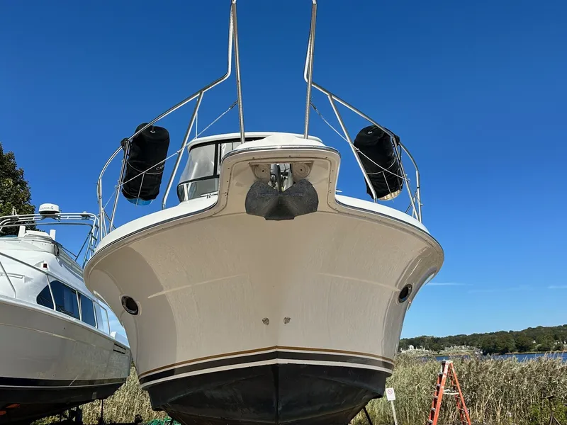 Slide: The Image of 2004 Silverton 38 Convertible boat on land, clear blue sky background. - 2