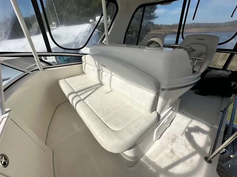 Slide: The Image of 2004 Silverton 38 Convertible yacht interior with white seating and helm station. - 23