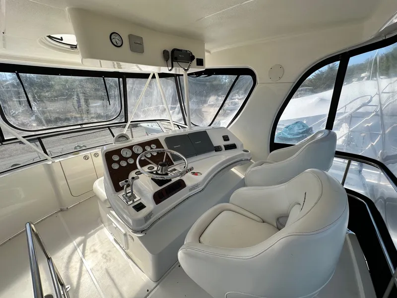 Slide: The Image of 2004 Silverton 38 Convertible yacht helm with dual seats and navigation controls. - 27