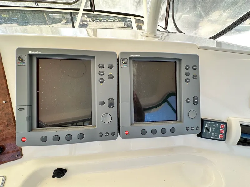 Slide: The Image of 2004 Silverton 38 Convertible boat dashboard with Raymarine navigation displays. - 31