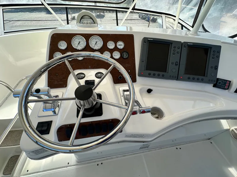 Slide: The Image of 2004 Silverton 38 Convertible helm with steering wheel, gauges, and navigation displays. - 32