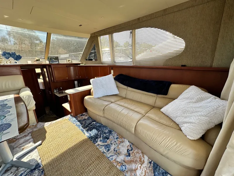 Slide: The Image of Interior of 2004 Silverton 38 Convertible yacht with beige leather sofa and wooden cabinetry. - 34