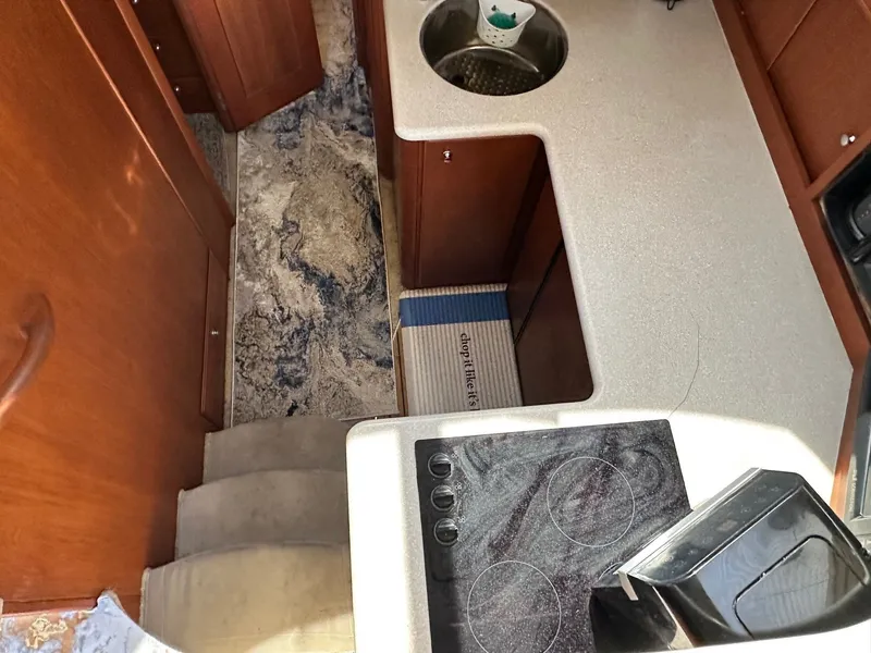 Slide: The Image of 2004 Silverton 38 Convertible yacht kitchen with stove, sink, and wooden cabinetry. - 41