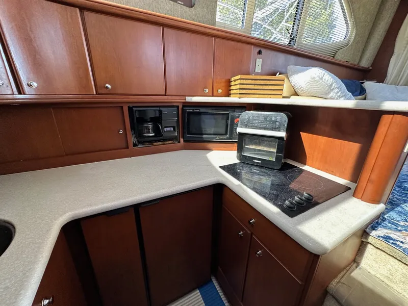 Slide: The Image of 2004 Silverton 38 Convertible yacht kitchen with stove, microwave, and coffee maker. - 45