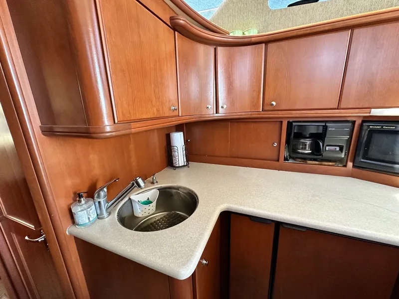Slide: The Image of 2004 Silverton 38 Convertible yacht kitchen with wooden cabinets and modern appliances. - 46