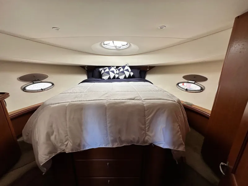 Slide: The Image of Luxurious cabin interior of 2004 Silverton 38 Convertible yacht with cozy bed and porthole windows. - 48