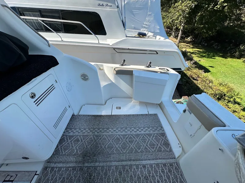 Slide: The Image of 2004 Silverton 38 Convertible yacht deck with seating and storage, featuring outdoor carpet. - 7