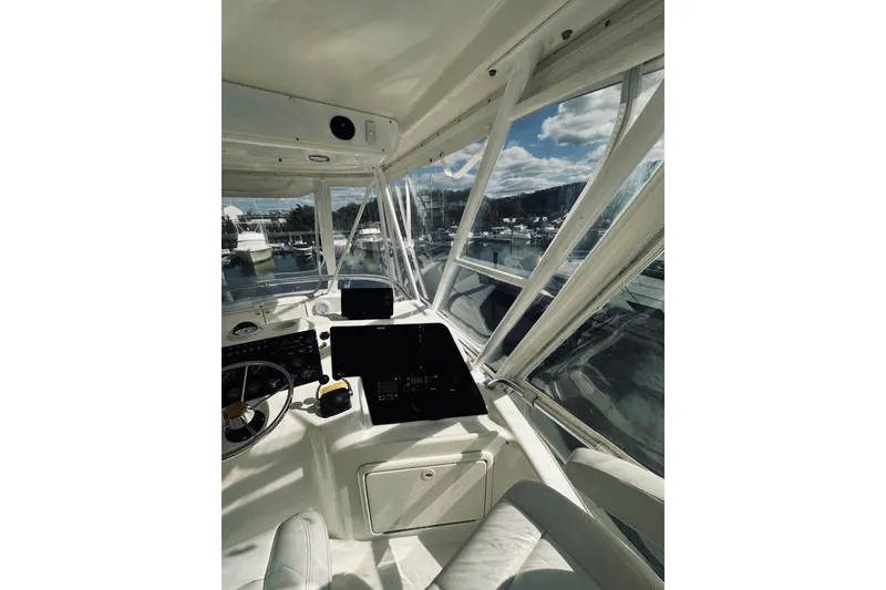 Slide: The Image of Interior view of 2000 Riviera 40 yacht helm with white captain chairs and navigation equipment. - 12