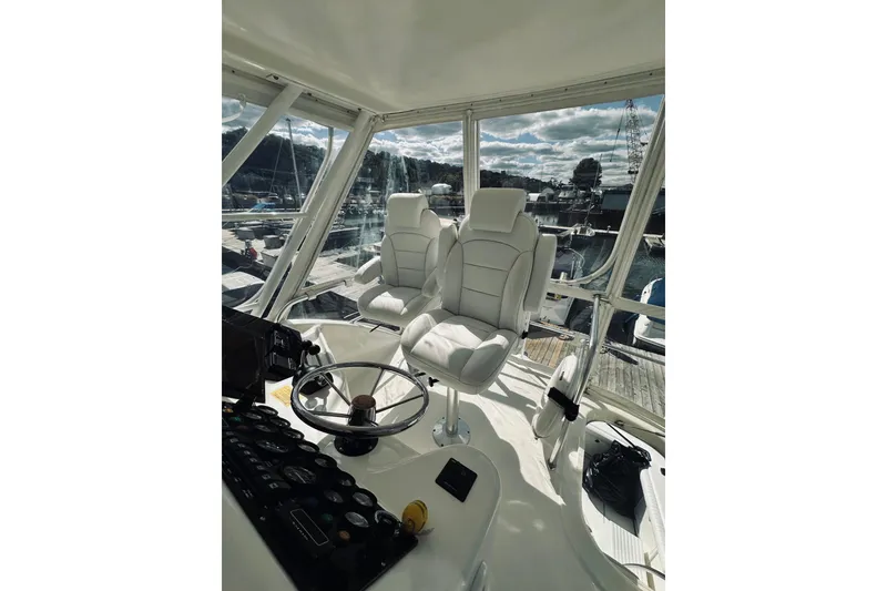 Slide: The Image of Interior view of 2000 Riviera 40 yacht at marina, showcasing seating and helm area. - 15