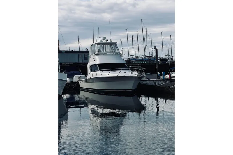 Slide: The Image of 2000 Riviera 40 yacht docked at marina under cloudy sky. - 2