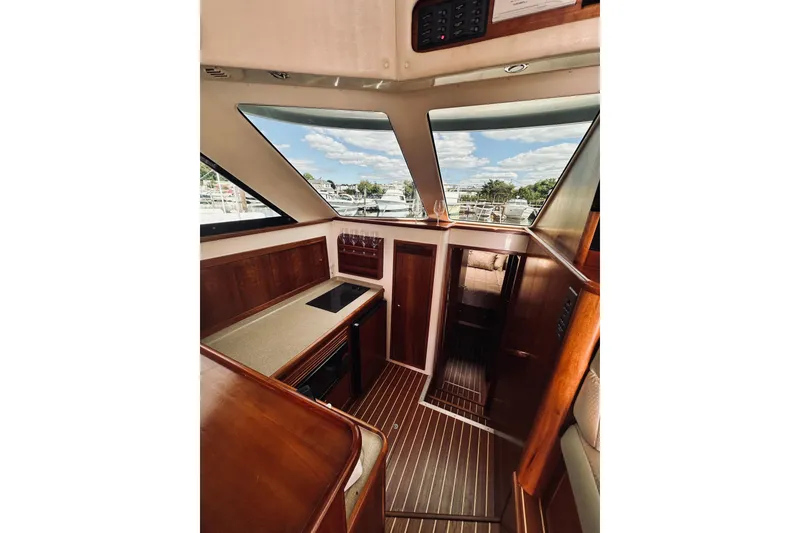 Slide: The Image of Interior of 2000 Riviera 40 yacht with wooden finishes and marina view. - 35