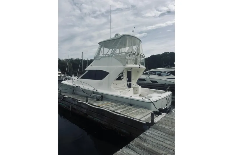 Slide: The Image of 2000 Riviera 40 yacht docked at marina under cloudy sky. - 4