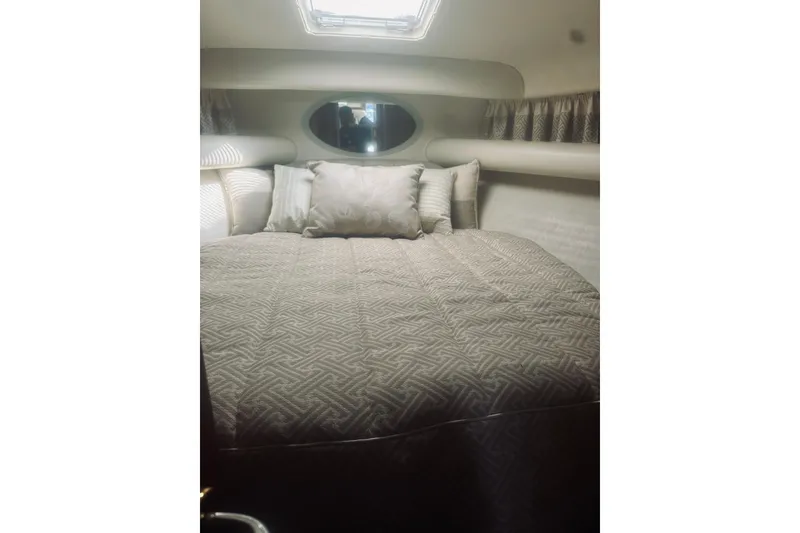 Slide: The Image of Interior of 2000 Riviera 40 yacht bedroom with bed, pillows, and wooden cabinet. - 42