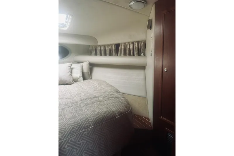 Slide: The Image of Interior cabin of 2000 Riviera 40 yacht with cozy bed and wooden accents. - 43