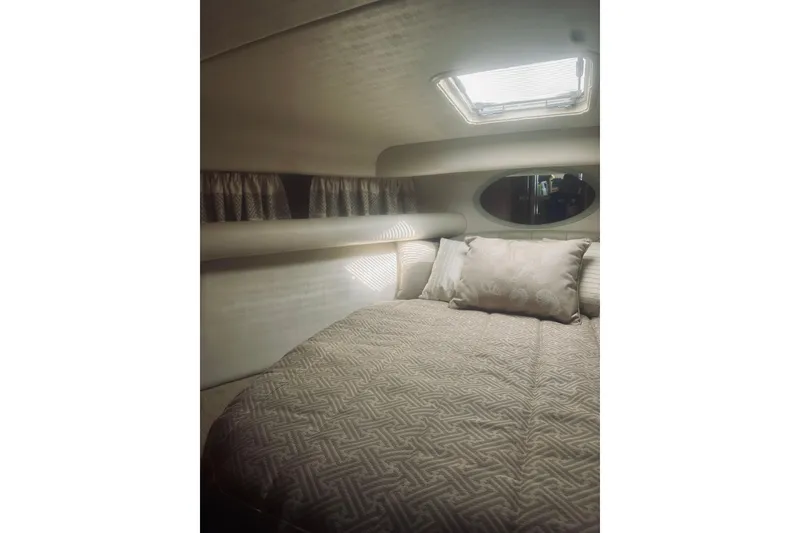 Slide: The Image of Wooden closet interior on a 2000 Riviera 40 boat, featuring hanging clothes and storage. - 45