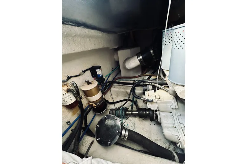 Slide: The Image of Engine compartment of a 2000 Riviera 40 boat, featuring mechanical components and hoses. - 57