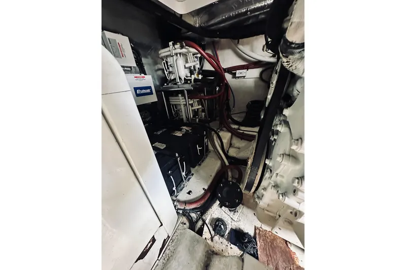 Slide: The Image of Engine room of a 2000 Riviera 40 boat, showcasing mechanical components and wiring. - 76