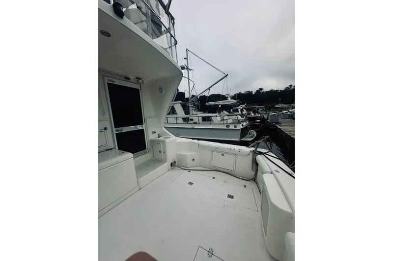 Slide: The Image of 2000 Riviera 40 yacht docked at marina, featuring spacious deck and sleek design. - 90