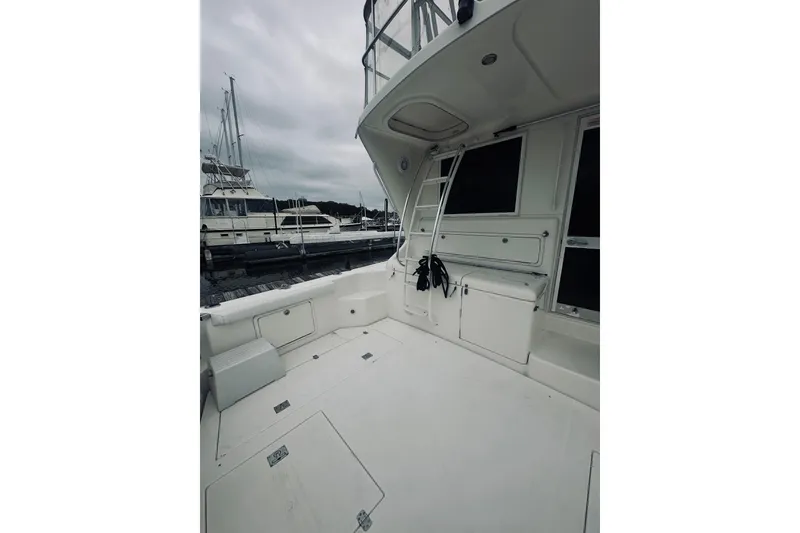 Slide: The Image of 2000 Riviera 40 yacht deck with storage, ladder, and marina view. - 91