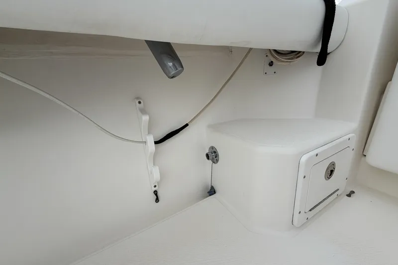 Slide: The Image of Interior view of a 1998 Cabo 31 Express boat, featuring storage compartment and seating. - 13
