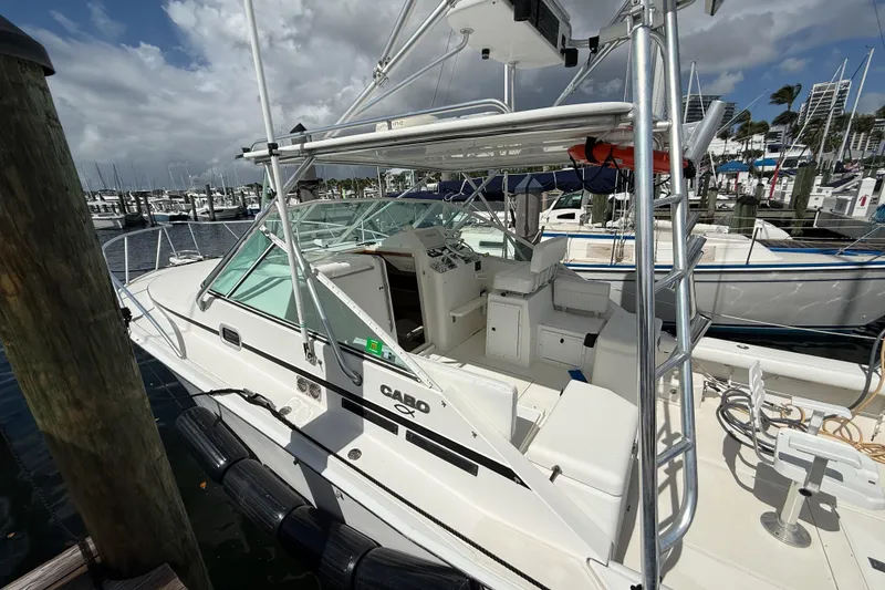 Slide: The Image of 1998 Cabo 31 Express boat docked at marina under cloudy sky. - 2