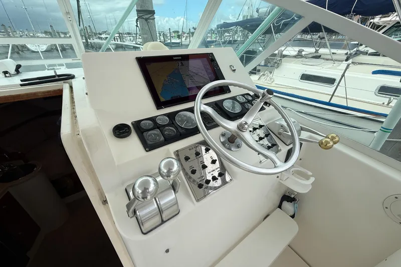 Slide: The Image of 1998 Cabo 31 Express boat helm with navigation controls and steering wheel. - 23