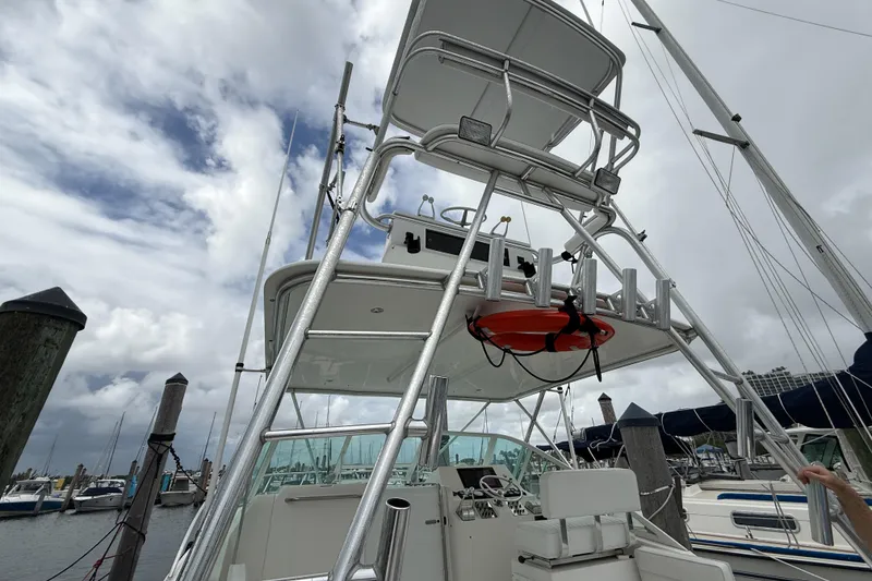 Slide: The Image of 1998 Cabo 31 Express boat with tower, docked under cloudy skies. - 26