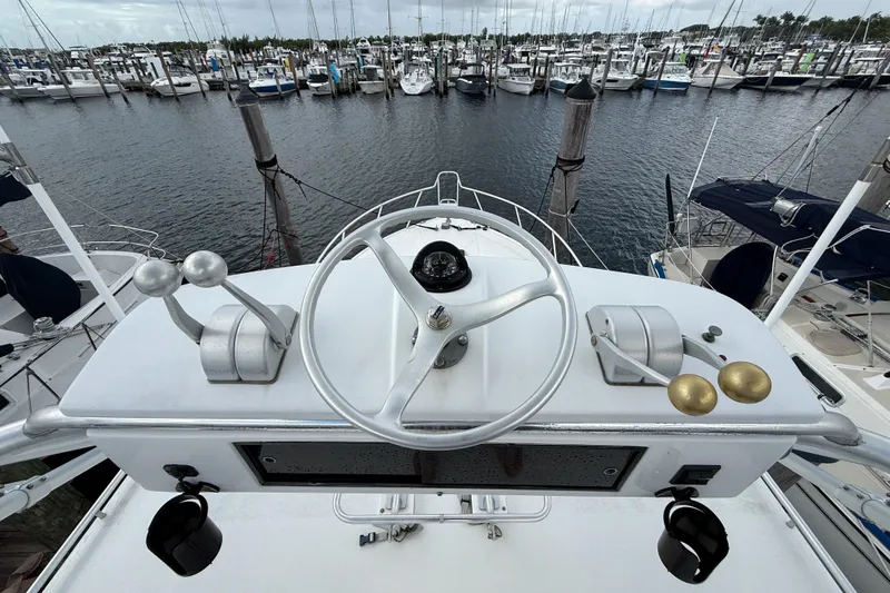 Slide: The Image of Helm of 1998 Cabo 31 Express boat overlooking marina with numerous docked vessels. - 28