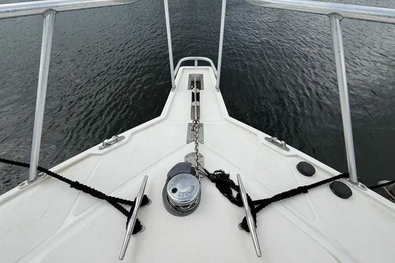 Slide: The Image of Bow of 1998 Cabo 31 Express boat with anchor and ropes on water. - 32