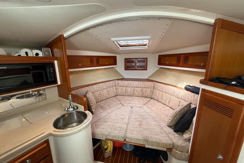 Slide: The Image of 1998 Cabo 31 Express cabin interior with kitchenette, seating area, and wooden cabinetry. - 37