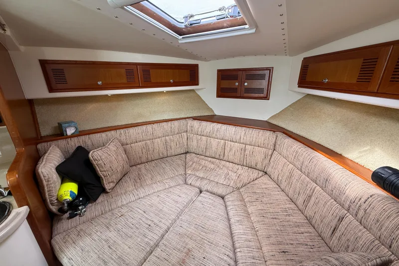 Slide: The Image of 1998 Cabo 31 Express cabin interior with cozy seating and wooden storage cabinets. - 38