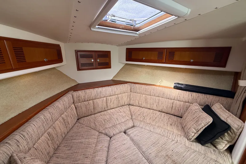 Slide: The Image of Cozy cabin interior of 1998 Cabo 31 Express with cushioned seating and wooden storage cabinets. - 39